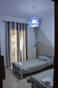 a bedroom with a bed and a chandelier at Liogerma in Agios Ioannis Kaspaka