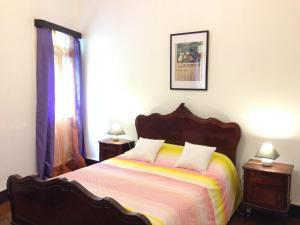 a bedroom with a bed and a lamp on the wall at Holidays Madeira in São Vicente
