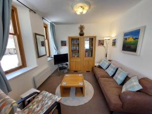 Shetland Cottage Kincraig في كينغكرايغ: غرفة معيشة مع أريكة وطاولة قهوة