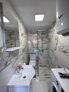 a white bathroom with a sink and a shower at Venice Apartments in Tivat