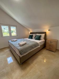 a bedroom with a large bed with two towels on it at Venice Apartments in Tivat