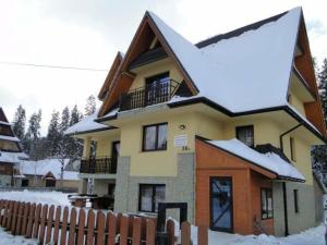 una casa en la nieve con una valla en uAntosi Małe Ciche en Murzasichle