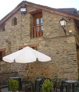 ein weißer Regenschirm vor einem Gebäude in der Unterkunft Casa Apartamento de montaña in Espúy