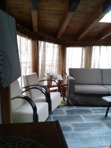 ein Wohnzimmer mit weißen Stühlen und einem Sofa in der Unterkunft Casa Apartamento de montaña in Espúy