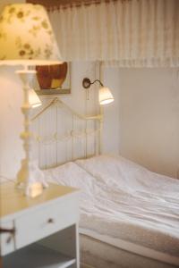 a bedroom with a white bed with a lamp on a table at Stevns Klint Bed & Breakfast in Store Heddinge