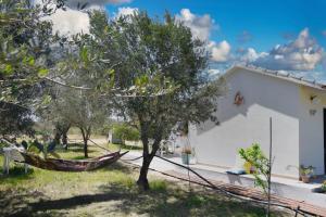 a hammock in a yard next to a house at Casa vacanze FELICI IN 2 - Santa Maria del Focallo - Ispica in Santa Maria Del Focallo