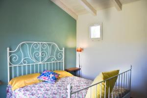 um quarto com uma cama com uma parede azul em Casa vacanze FELICI IN 2 - Santa Maria del Focallo - Ispica em Santa Maria Del Focallo
