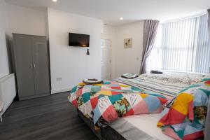 a bedroom with a bed with a colorful quilt at TCO Luxury House in Liverpool