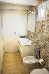 uma casa de banho com um WC, um lavatório e um espelho. em Casa vacanze FELICI IN 2 - Santa Maria del Focallo - Ispica em Santa Maria Del Focallo