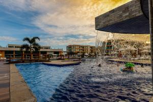 ein Swimmingpool mit Springbrunnen in einem Resort in der Unterkunft Muro Alto Condomínio Clube - FLAT TÉRREO in Porto De Galinhas
