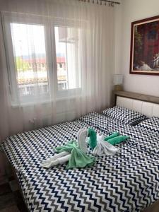 a bedroom with a black and white bed with a window at Tri palme in Banja Koviljača