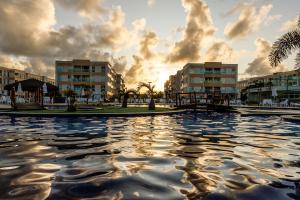 einem Wasserpool vor einigen Gebäuden in der Unterkunft Muro Alto Condomínio Clube - FLAT TÉRREO in Porto De Galinhas