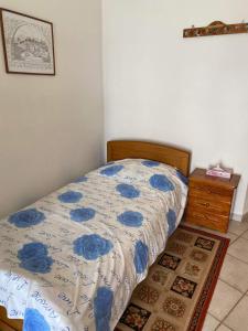 a bed with a blue and white comforter in a bedroom at Fabrica apartments in Apérathos