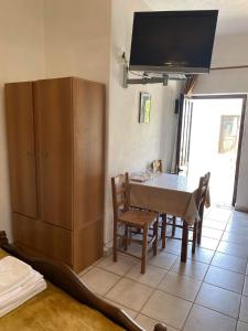 a kitchen with a dining room table and a tv at Fabrica apartments in Apeiranthos