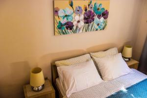 1 dormitorio con 1 cama con 2 lámparas y 1 pintura en Apartment Rajevac, en Dubrovnik
