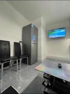 Cette chambre comprend deux tables et un réfrigérateur. dans l'établissement Entire 5 Star Luxury Whalley House Wifi TV Luxury, à Burnley