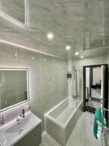 La salle de bains est pourvue d'une baignoire, d'un lavabo et d'un miroir. dans l'établissement Entire 5 Star Luxury Whalley House Wifi TV Luxury, à Burnley