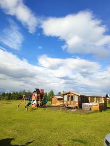 a yard with a house and a playground at Cosy Cabin by Lake & Woods with Views in Selfoss