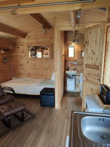 Habitación con cama en una cabaña de madera en Cosy Cabin by Lake & Woods with Views, en Selfoss