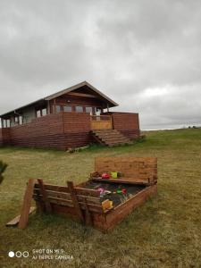 a building with a sandbox in front of a house at Cosy Cabin by Lake & Woods with Views in Selfoss