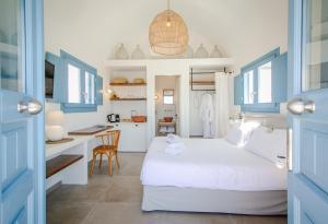 une chambre avec un lit et un bureau dans une pièce dans l'établissement Vino Houses Santorini, à Oia