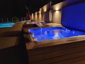 a jacuzzi tub sitting next to a pool at night at Casa Del Torrente in Porto Ota