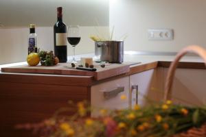 Apartment Na Krki في Kostanjevica na Krki: مطبخ مع زجاجة من النبيذ وكأس من النبيذ