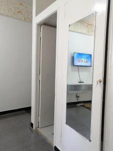 una puerta abierta a una habitación con TV en la pared en Golden Nest en Mombasa