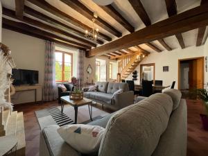 a living room with a couch and a table at Proche le Mans, Parigné l'Evêque,maison forestière, accueil chevaux possible 11 pers in Parigné-lʼÉvêque