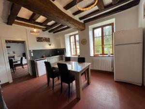 uma cozinha com mesa e cadeiras num quarto em La Bergerie - Forêt - 10 Personnes em Parigné-lʼÉvêque