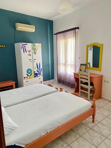 Schlafzimmer mit einem Bett, einem Schreibtisch und einem Spiegel in der Unterkunft Mitato Studios in Myrtos