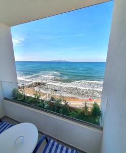 a bathroom with a view of the ocean from a window at Sunset Beach Hotel in Kokkíni Khánion