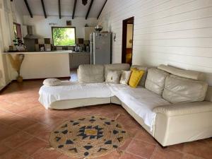 a large white couch in a room with a kitchen at Villa Petitparadis in Le Carbet