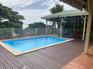 a swimming pool on a deck with a gazebo at Villa Petitparadis in Le Carbet