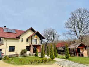 a large white house with a red roof at Pensiunea 7 Brazi in Poiana Mărului