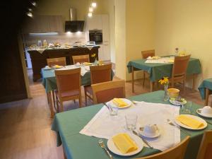 a dining room with green tables and chairs and a kitchen at Zeilinger Villa in Knittelfeld