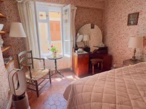 1 dormitorio con cama, silla y escritorio en La Chambre Rose-Maison Searle à Tourtour, en Tourtour
