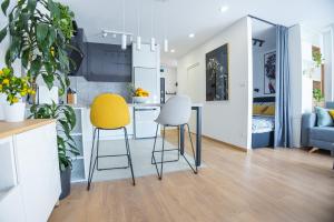 萨格勒布Dada's Cosy Condo的一间厨房,里面配有两把黄色和白色的椅子