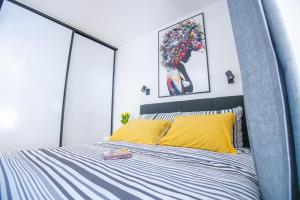 a bedroom with a large bed with yellow pillows at Dada's Cosy Condo in Zagreb