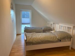 a bedroom with a bed and a window at Ferienwohnung am Plöner See in Ascheberg