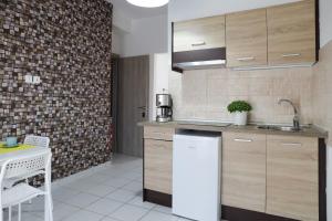 a kitchen with wooden cabinets and a white refrigerator at Modern Apartments Edipsos in Loutra Edipsou