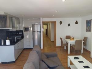 kuchnia i salon z kanapą i stołem w obiekcie Apartemento Pablo w Santiago de Compostela