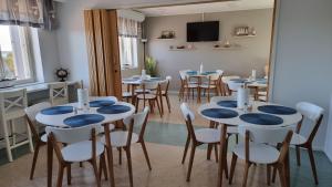 a dining room with blue tables and chairs at Hotel Vanha-Merivartioasema in Kotka