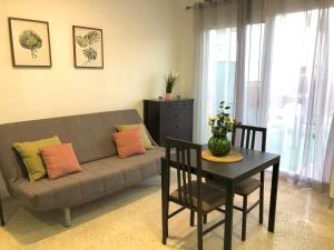 uma sala de estar com um sofá e uma mesa em Apartamento con piscina en Ciudad Jardín em Málaga