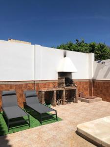 een patio met 2 stoelen en een open haard bij Apartamento con piscina en Ciudad Jardín in Málaga