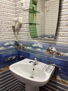 een badkamer met een wastafel en een spiegel bij Hotel Rahmon in Samarkand
