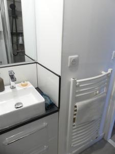 W łazience znajduje się biała umywalka i lustro. w obiekcie La Casita - Studio Confort avec Terrasse et Parking privé - La Grande Motte, Montpellier w mieście La Grande-Motte