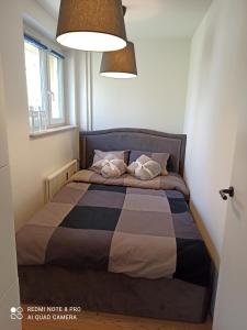 uma cama com duas almofadas num quarto em Studio Park Śląski m.10 Katowice/Chorzów em Chorzów