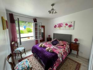ビダールにあるAppartement entre 2 plagesのベッドルーム(紫色のベッド1台、窓付)