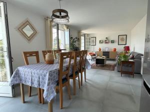 a dining room and living room with a table and chairs at Appartement entre 2 plages in Bidart